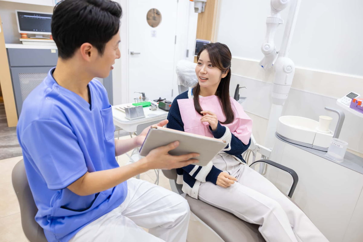 歯科医と笑顔で治療について話している患者